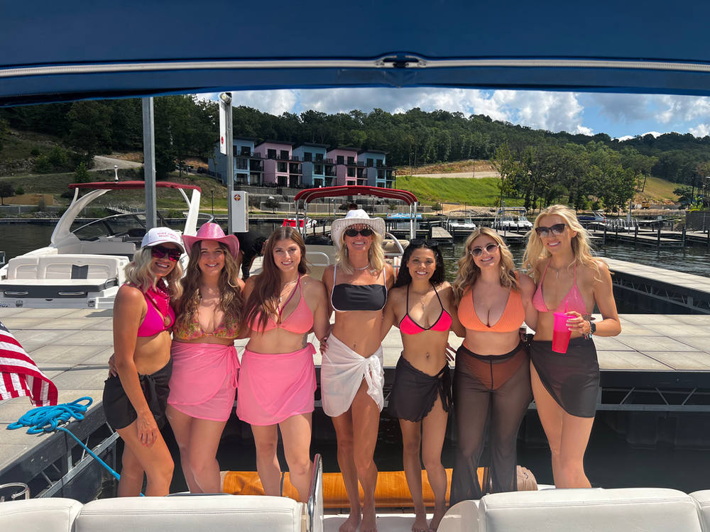 Bachelorette group in pink cowboy hats on the dock before boarding
