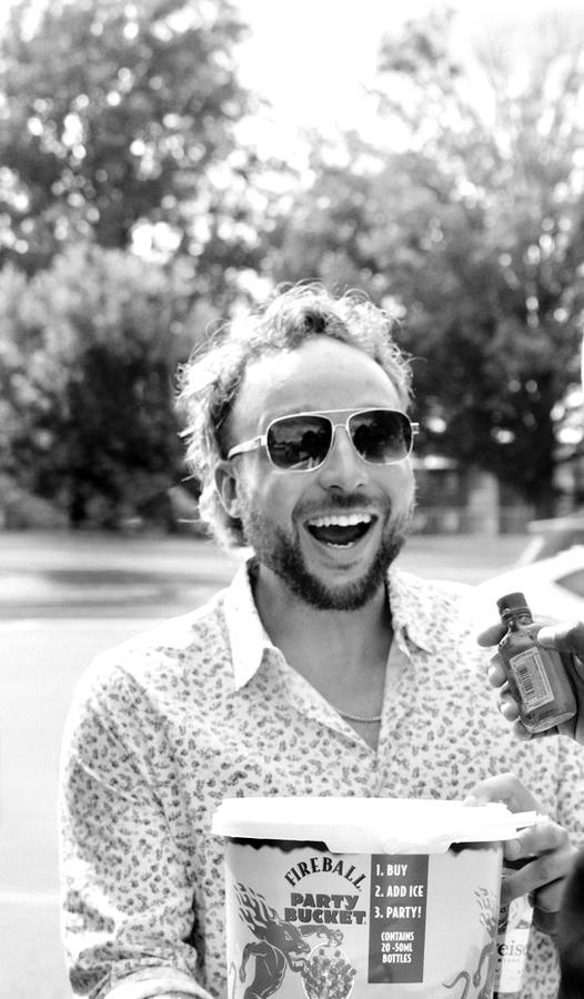 Capt. Stove laughing in sunglasses, holding a Fireball party bucket