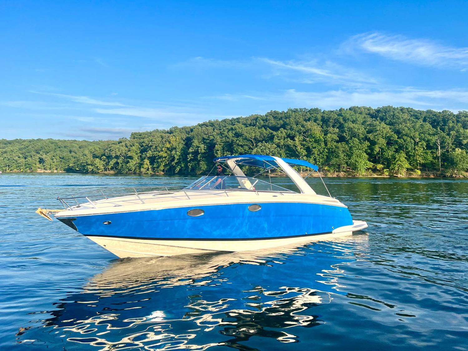 C'est La Vie, a blue 35-foot Regal sport cruiser, anchored on calm water at Lake of the Ozarks