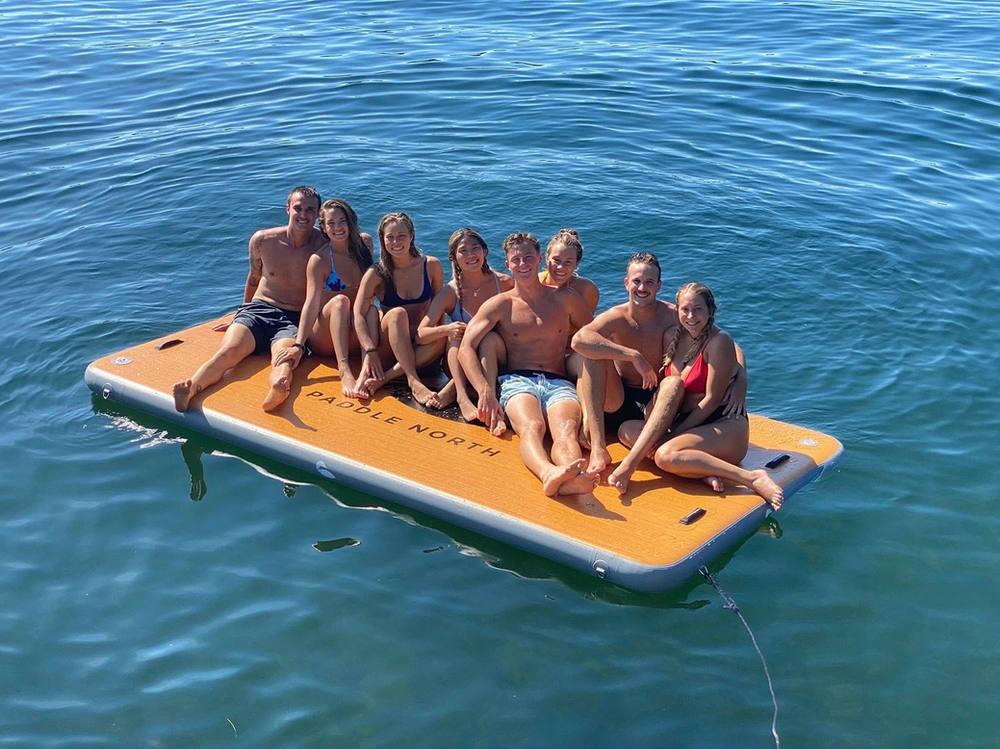 Group lounging on the inflatable lily pad floating beside the boat