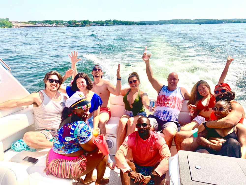 Full charter group underway with arms in the air, wake trailing behind the boat