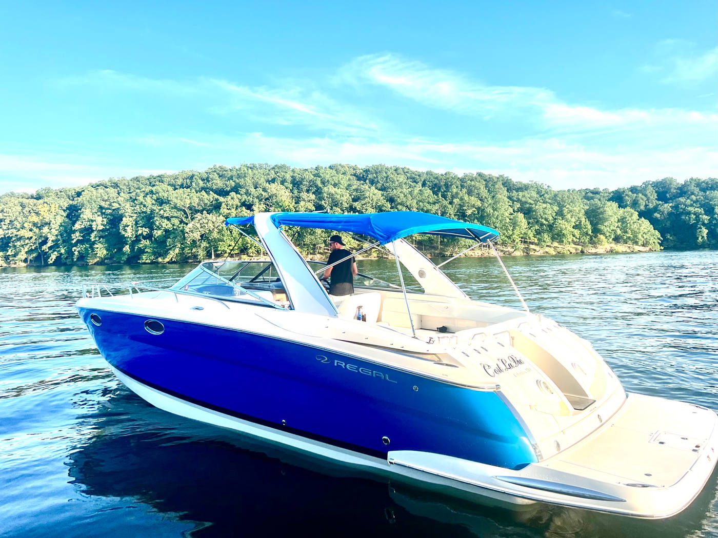 Stern view of C'est La Vie at anchor with the blue bimini top up