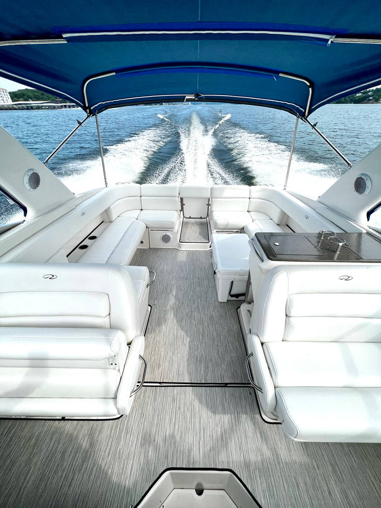 The open cockpit of the Regal 35 underway, white wraparound seating with the wake behind